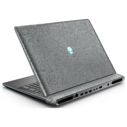 Rear left three-quarter view of an open Alienware 18 Area-51 (2025) with Classic Gray Hibiscus skin, showing the floral lid and keyboard deck to the left.
