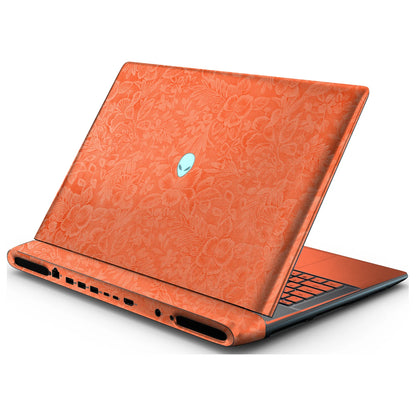 Rear right three-quarter view of an open Alienware 18 Area-51 (2025) with Sunset Orange Hibiscus skin, showing the floral lid and keyboard deck to the right.
