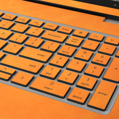 Orange scrub-textured synthetic leather Dell business laptop skin, macro view. Rendered on Dell Pro 16 PC16250 as a reference; exact cut layout follows the selected model and coverage.