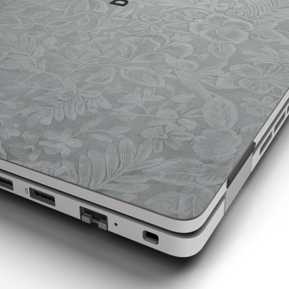 Hibiscus-embossed top lid material close-up of Classic Gray Hibiscus synthetic leather skin, rendered on Dell Pro 16 (PC16250) as a model reference.