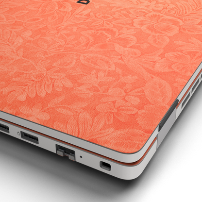 Hibiscus-embossed top lid material close-up of Sunset Orange Hibiscus synthetic leather skin, rendered on Dell Pro 16 (PC16250) as a model reference.