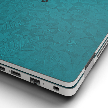 Hibiscus-embossed top lid material close-up of Tropical Teal Hibiscus synthetic leather skin, rendered on Dell Pro 16 (PC16250) as a model reference.