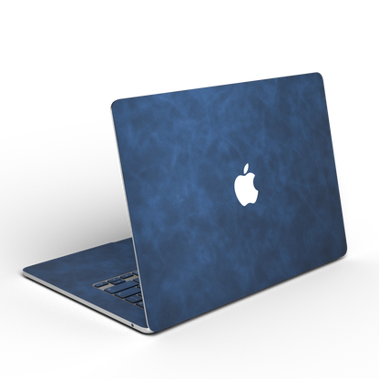 Dark Gray Blue scrub-textured synthetic leather MacBook skin. Open rear angle material illustration. Air 15.3 M3-M5 shared material/installation reference; exact cutouts and included pieces follow selected model and coverage. Laptop not included.