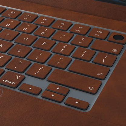Coffee Brown scrub-textured synthetic leather MacBook skin. Close-up of the actual scrub-textured material finish. Air 15.3 M3-M5 shared material/installation reference; exact cutouts and included pieces follow the selected model and coverage. Laptop not included.