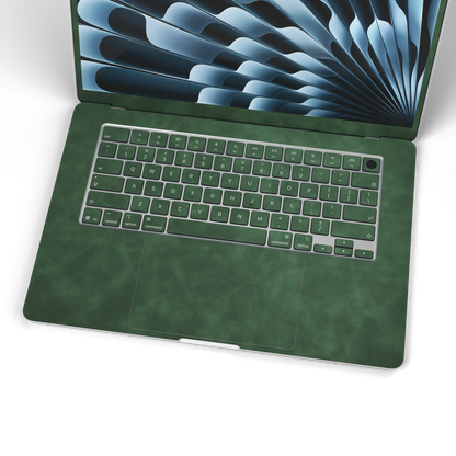 Green scrub-textured synthetic leather MacBook skin. Wide keyboard and inside material detail. Air 15.3 M3-M5 shared material/installation reference; exact cutouts and included pieces follow selected model and coverage. Laptop not included.