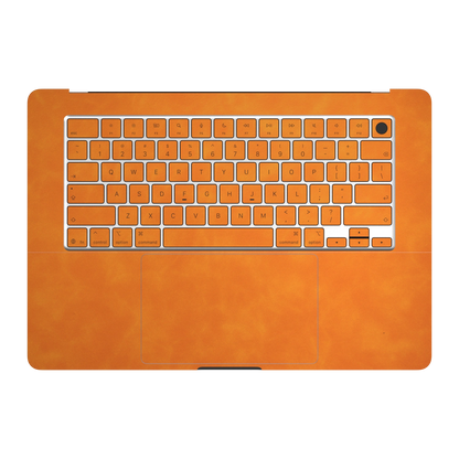 Orange scrub-textured synthetic leather MacBook skin. Inside (C), keyboard deck and matching keycap material illustration. Air 15.3 M3-M5 shared material/installation illustration; actual cutouts and included pieces follow the selected model and coverage. Laptop not included.