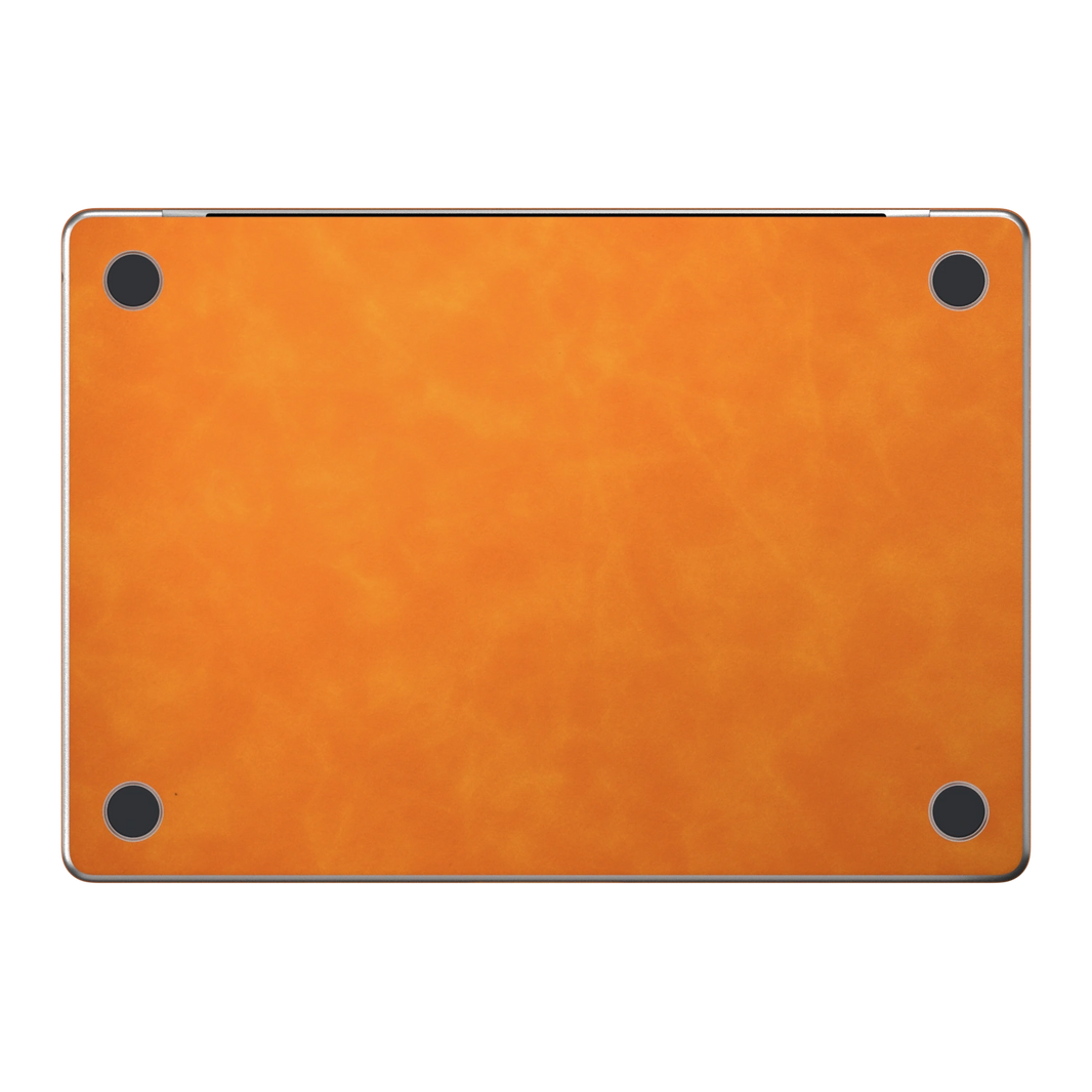 Orange scrub-textured synthetic leather MacBook skin. Bottom (D) material illustration; included only with bottom coverage. Air 15.3 M3-M5 shared material/installation illustration; actual cutouts and included pieces follow the selected model and coverage. Laptop not included.