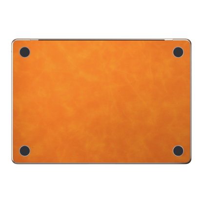 Orange scrub-textured synthetic leather MacBook skin. Bottom (D) material illustration; included only with bottom coverage. Air 15.3 M3-M5 shared material/installation illustration; actual cutouts and included pieces follow the selected model and coverage. Laptop not included.